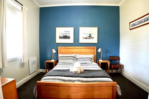 a bedroom with a bed with a blue wall at Homesaway Cottage in Kyneton