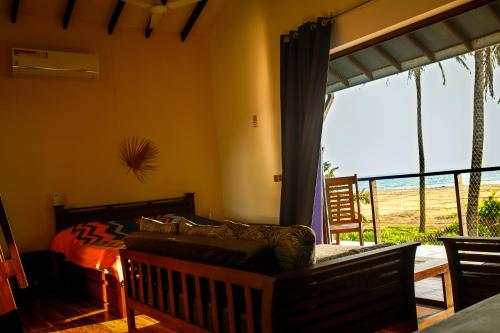 a bedroom with a bed and a large window at Nayan's Paradise in Kottanitivu