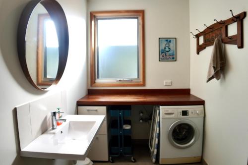 a bathroom with a sink and a washing machine at Homesaway Cottage in Kyneton