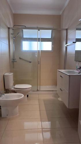 a bathroom with a toilet and a shower and a sink at Gloria's House in Lagoa