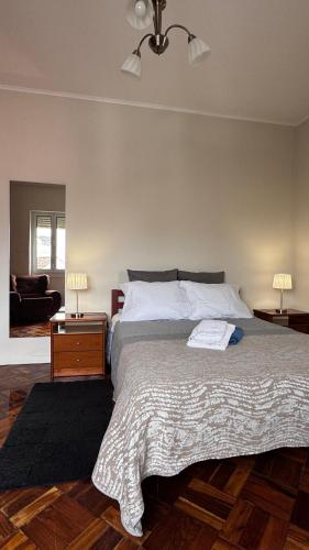 a bedroom with a large bed and a living room at Gloria's House in Lagoa