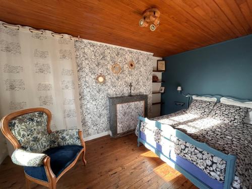 a bedroom with a bed and a chair at Maison Lilas in Pontarion