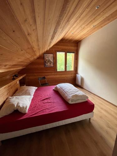 a large bed in a room with a wooden ceiling at le saint genest in Vallouise