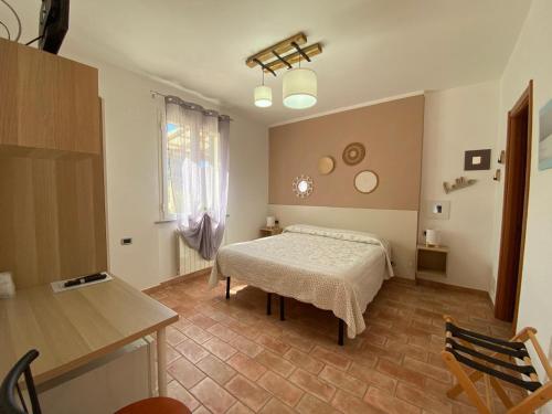 a bedroom with a bed and a table and a window at Locanda Cà de Rusitta in Vezzi Portio