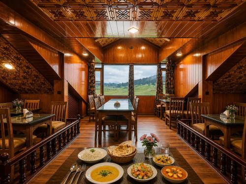 a dining room with a table with plates of food at Pine View Resort in Gulmarg