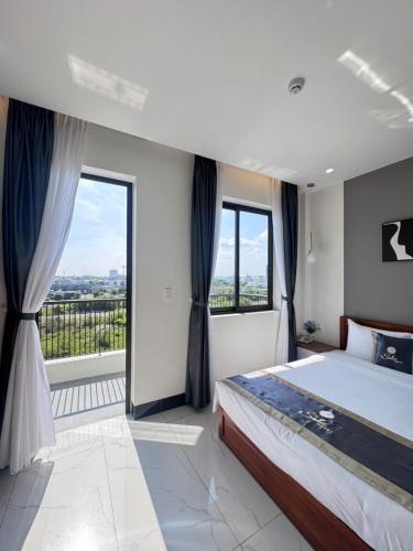 a bedroom with a large bed and a large window at Soha Hotel Cần Thơ in Cái Răng