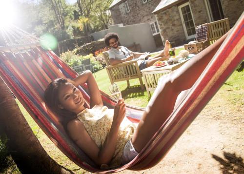a woman laying in a hammock in a yard at Kilminorth Cottages in Trelaske