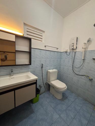 a bathroom with a toilet and a sink and a shower at JKAB Park Hotel in Trincomalee
