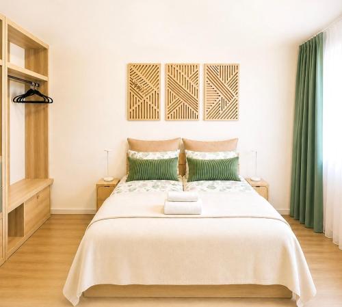 a bedroom with a large white bed with green pillows at Apartment Ypsilon am Grün in Bayreuth