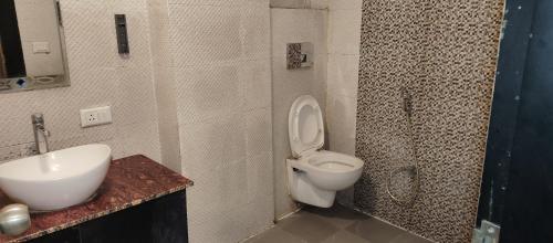 a bathroom with a toilet and a sink and a shower at Hotel Renuka Inn A Unite shyam ganga builders in Deoria
