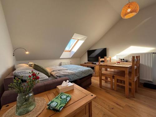 a living room with a bed and a desk and a table at Apartmán Kašperk in Vacov
