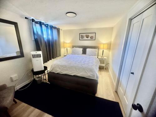 a small bedroom with a bed and blue curtains at Airport Getaway- 4 mins from Airport in Dieppe