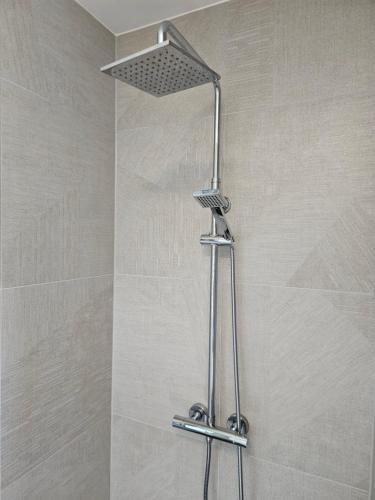 a shower with a shower head in a bathroom at Dugneberg in Karmøy