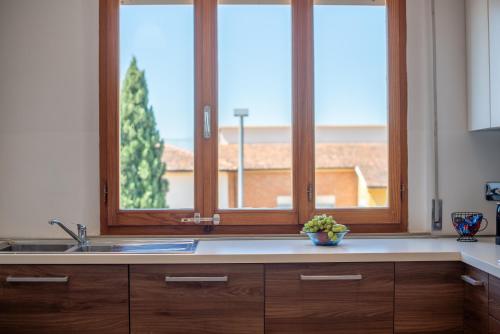 a kitchen with a sink and two windows at Appartamento BePlace - Le Crete in Rapolano Terme
