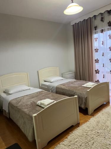 a bedroom with two beds and a rug at Camping & Guest House Herges in Udënisht