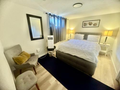 a bedroom with a large bed and a chair at Airport Haven Getaway in Dieppe