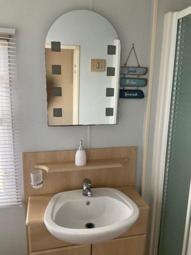 a bathroom with a sink and a mirror at Konies Place Golden Anchor Free WiFi Bedding Included in Chapel Saint Leonards