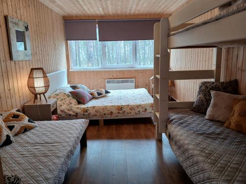 a bedroom with two bunk beds and a lamp at Männi puhkebaas in Karjamaa