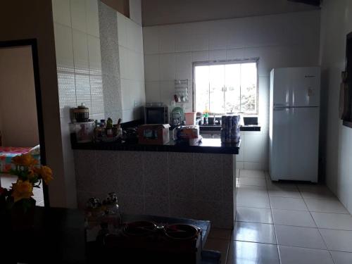 a kitchen with a white refrigerator and a window at Rancho dos dourados in Três Marias