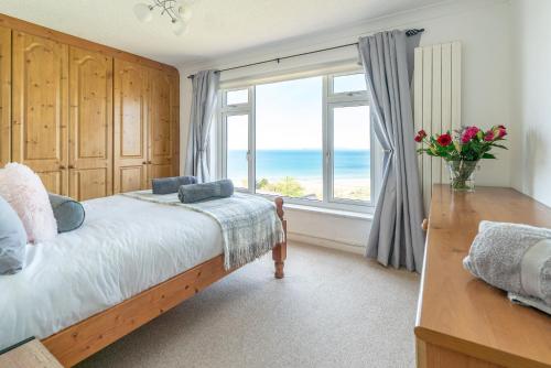 a bedroom with a bed and a window with the ocean at Ty-Mari in Harlech