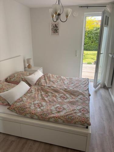 a bedroom with a bed with a comforter at Rose Garden in Hessisch Oldendorf