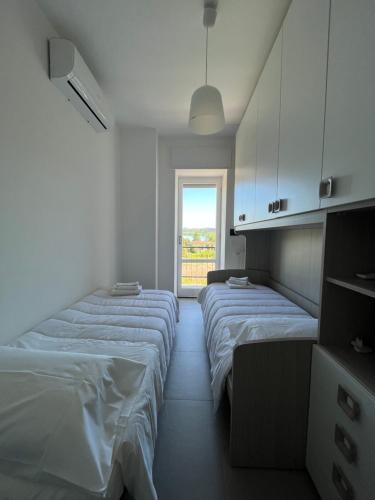 a row of beds in a room with a window at Lake view apartment in Dormelletto