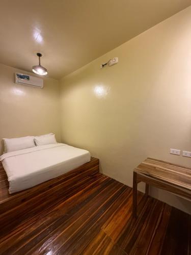 a small bedroom with a bed and a table at 9 Keys Inn in San Vicente