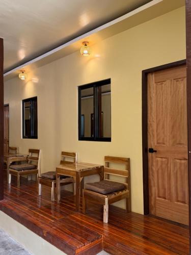 a room with wooden tables and chairs and a door at 9 Keys Inn in San Vicente
