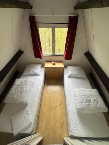 a small room with two beds and a window at Boshuis Green Forest in Durbuy