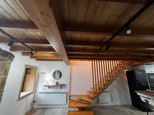a staircase in a room with wooden ceilings at Casa Erundina in Camariñas