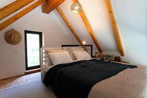ein Schlafzimmer mit einem großen Bett im Dachgeschoss in der Unterkunft Riverview cabin in Straža