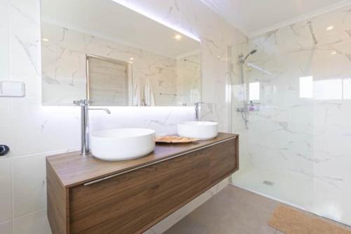 a bathroom with two sinks on a wooden counter with a shower at Villa Aqua Vista in Jávea