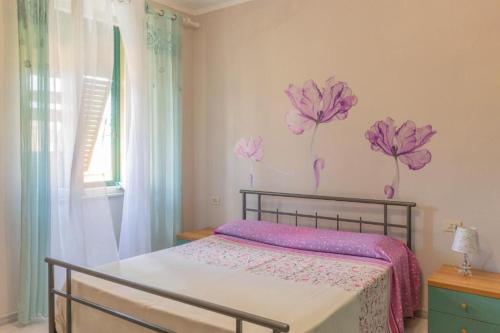 a bedroom with a bed with pink flowers on the wall at Casa Azzurra in Portoferraio