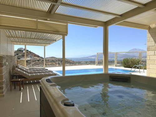 a hot tub in a house with a view at Villa Ovgoro - Luxury 3-Level Villa with Heated Pool, Jacuzzi and Panoramic Views in Kamilari