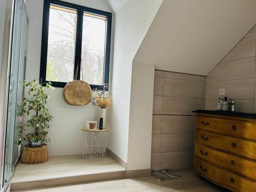 a bathroom with a window and a wooden dresser at Villa de Standing, Climatisation, Piscine chauffée & Nature in La Chapelle-Saint-Aubin