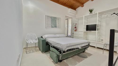 a white room with a bed and a tv at Civico5 - Spazioso appartamento 110 mq a Cefalù in Cefalù