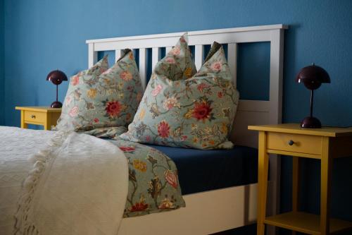 a bedroom with a bed with pillows and blue walls at auf der Muehle zwei in Zerbst