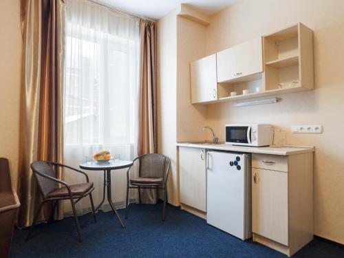a kitchen with a table and chairs and a microwave at Asotel in Kharkiv