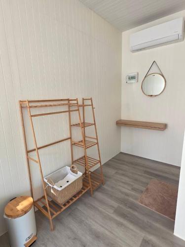 a room with a shelf and a mirror on the wall at Kanchana home stay กาญจนา โฮมสเตย์ สุราษฏร์ in Ban Bo Thong