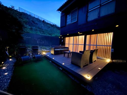 a backyard with a deck with furniture and lights at 一棟貸し宿 maicca2 in Numazu