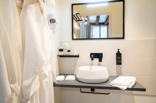 a bathroom with a sink and a mirror at L'Hostellerie de La Licorne in Fontevraud-l'Abbaye
