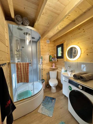 a bathroom with a shower and a toilet and a sink at Dom nad Saskiem 3 sypialnie, jacuzzi-relaks, natura i komfort in Linowo
