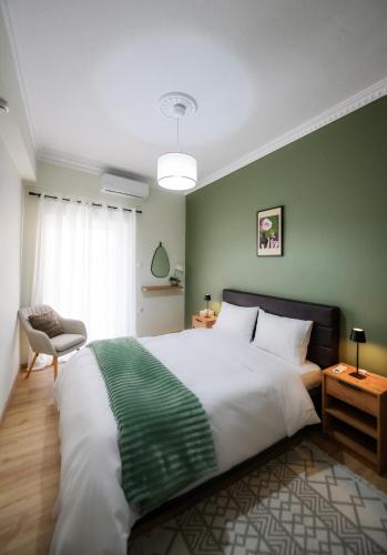 a bedroom with a large bed with a green wall at Patithries Apartments in Kalymnos
