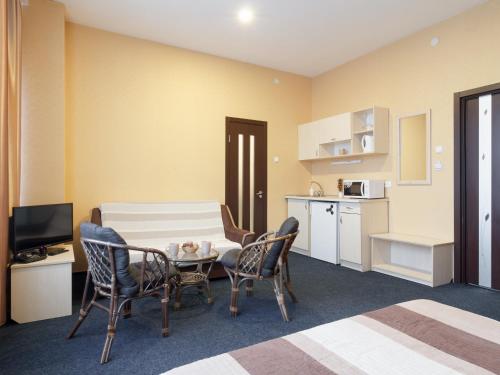 a hotel room with a table and chairs and a kitchen at Asotel in Kharkiv