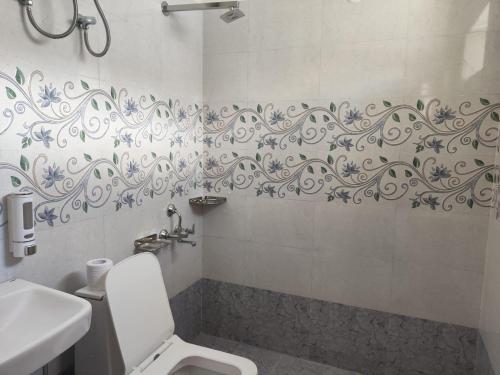a bathroom with a white toilet and a sink at Ochre Spiti in Lara