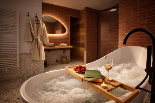 a bathroom with a bath tub with a glass of wine at Le lofty in Stoumont