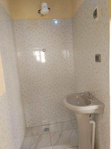 a white bathroom with a sink and a shower at Casa Oruro Valvic in Oruro
