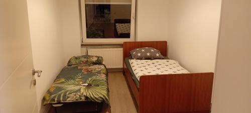 a small room with two beds and a window at Saarlouis in Saarlouis