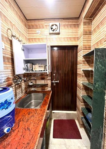 a kitchen with a sink and a wooden door at PARADISE VILLA Near Prem Mandir in Vrindāvan