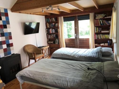 a bedroom with two beds and a desk and a chair at De Merel in Pieterburen